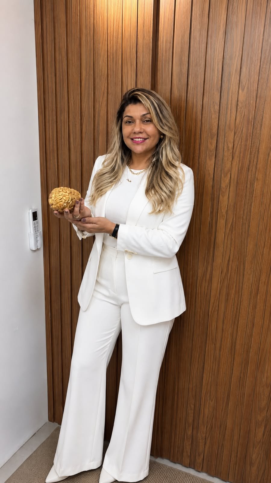 Juliene Cordeiro segurando peça decorativa em formato de cérebro, referência à neuropsicologia